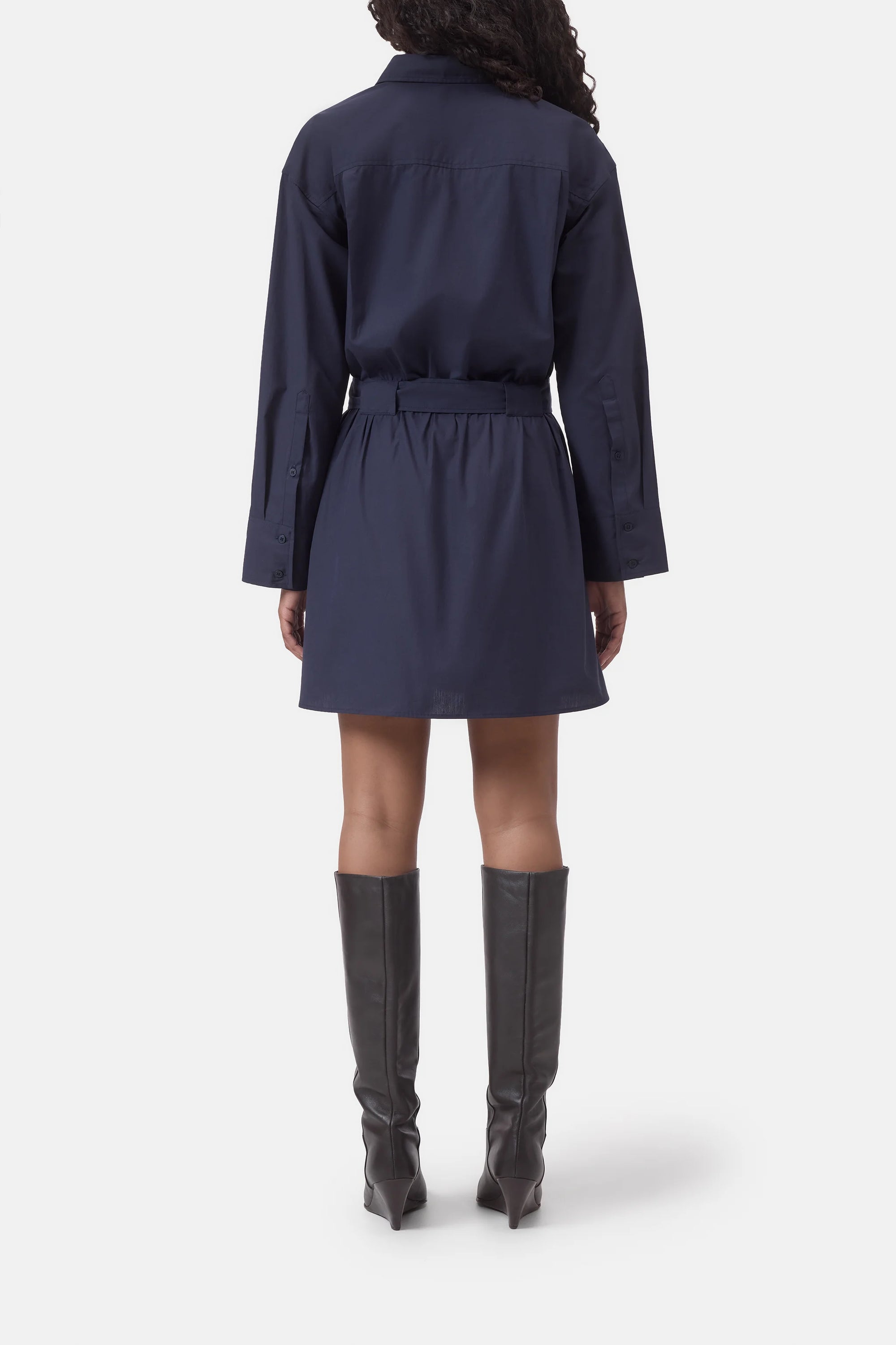 Navy belted shirt dress by CLOSED, back view, styled with knee-high black boots on white background.