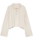 The DOEN Cambridge Cashmere Sweater is cream-colored, cable-knit, and features a Henley collar with three buttons, long wide sleeves, a cropped uneven hem, and a soft, cozy look.
