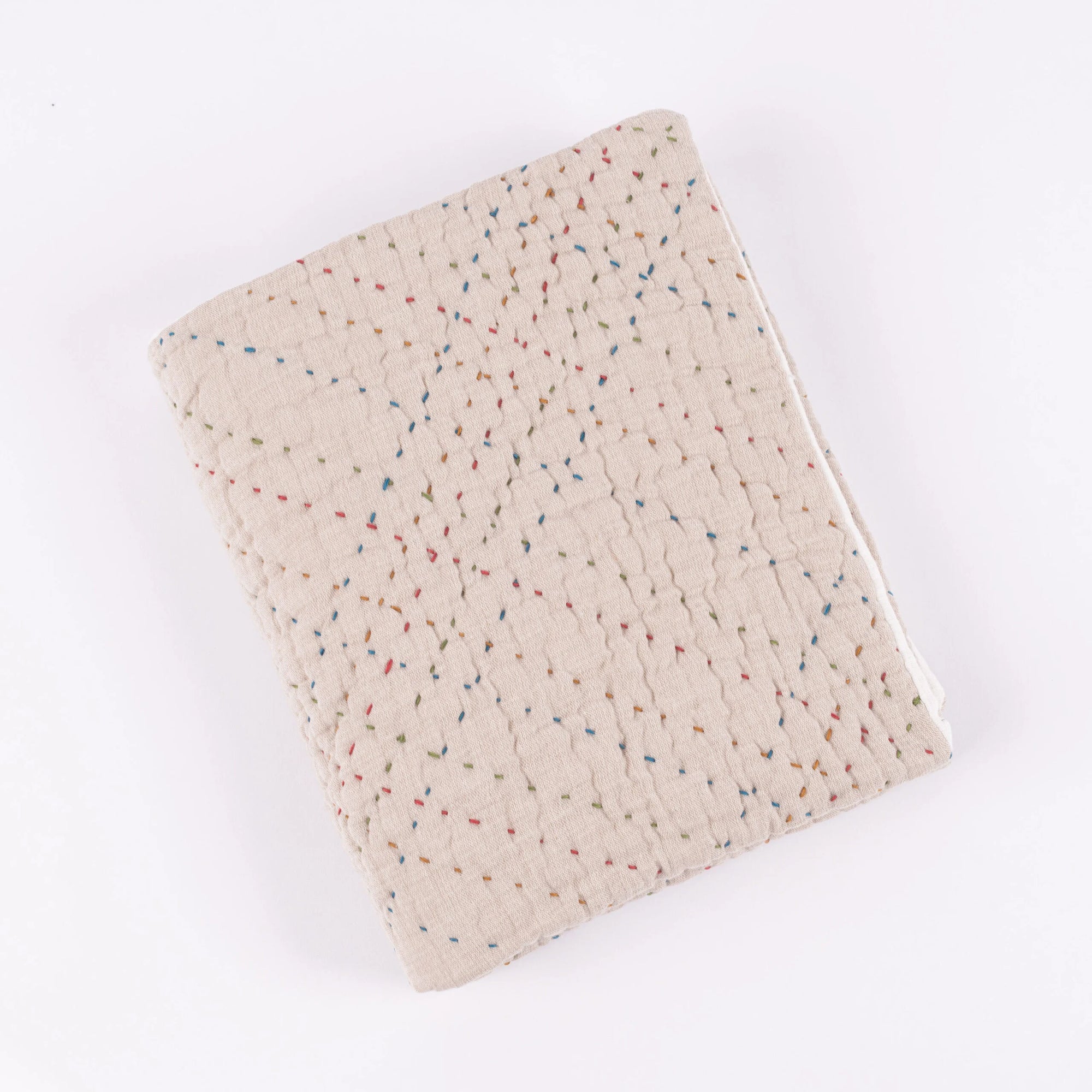 Beige handmade quilt with textured surface and colorful geometric dots by Amity Home, Mendel collection.