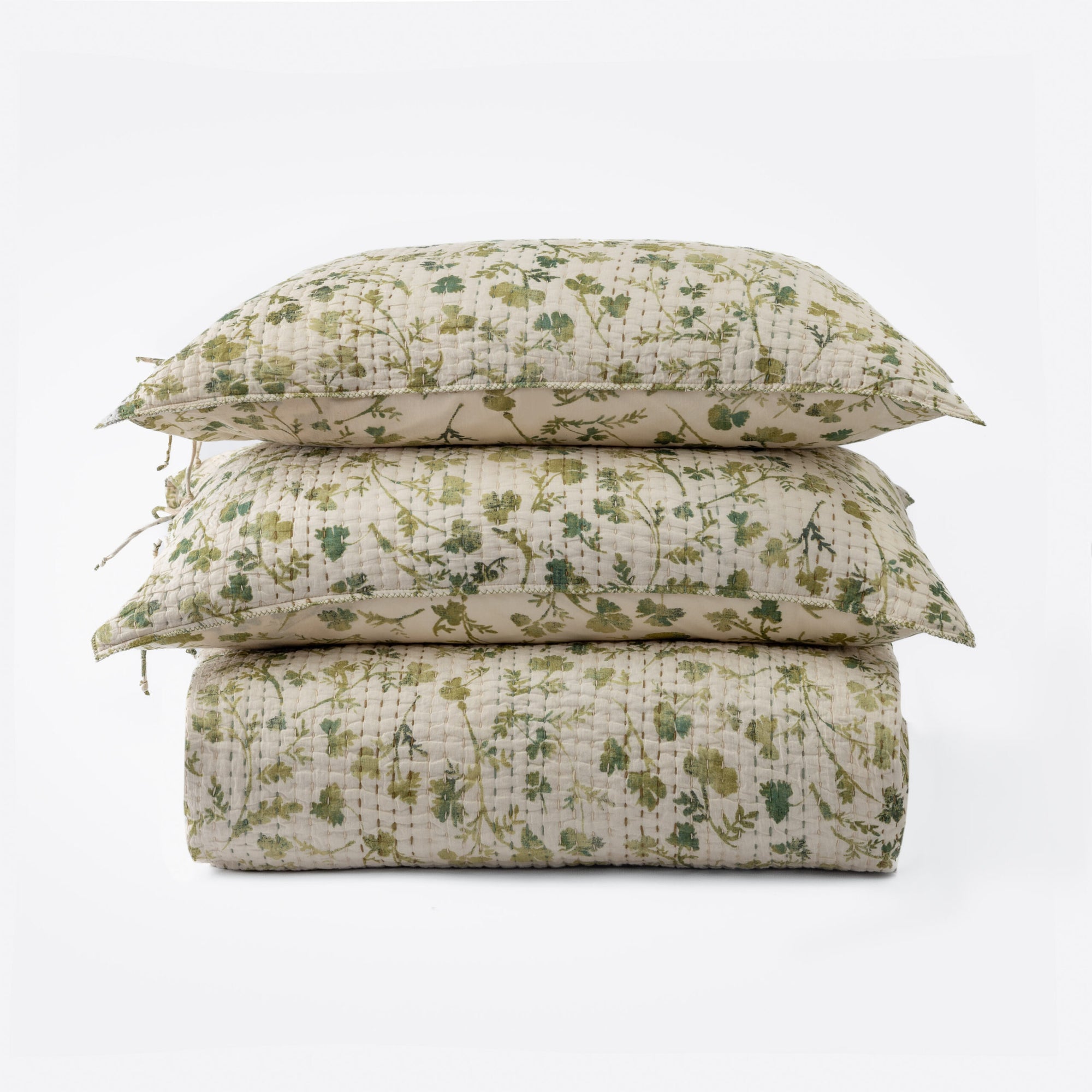 A neatly stacked set features two Millie Euro Shams and a quilt by Amity Home, all with a green and beige solar print floral pattern on soft cotton voile, arranged against a plain white background.