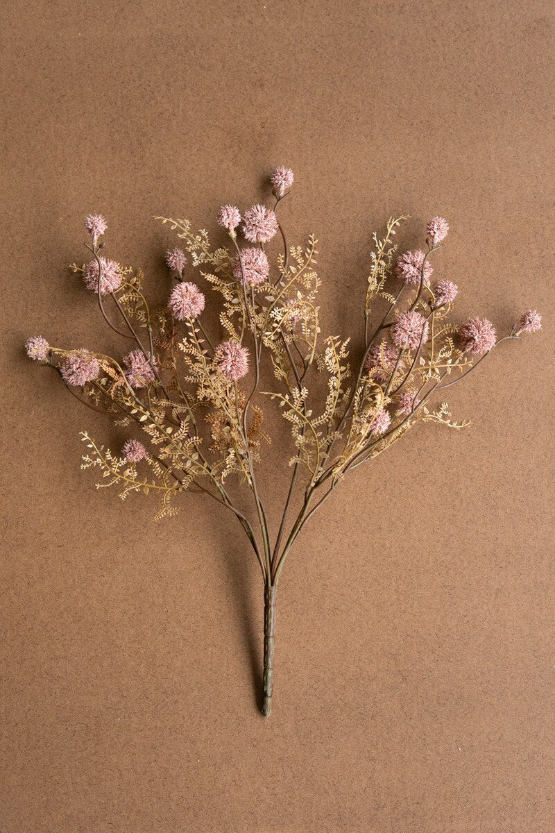 The Pink Melaleuca by Kalalou, Inc features dried wildflowers with rosy pink hues and delicate brown stems, artfully arranged on a plain brown background.