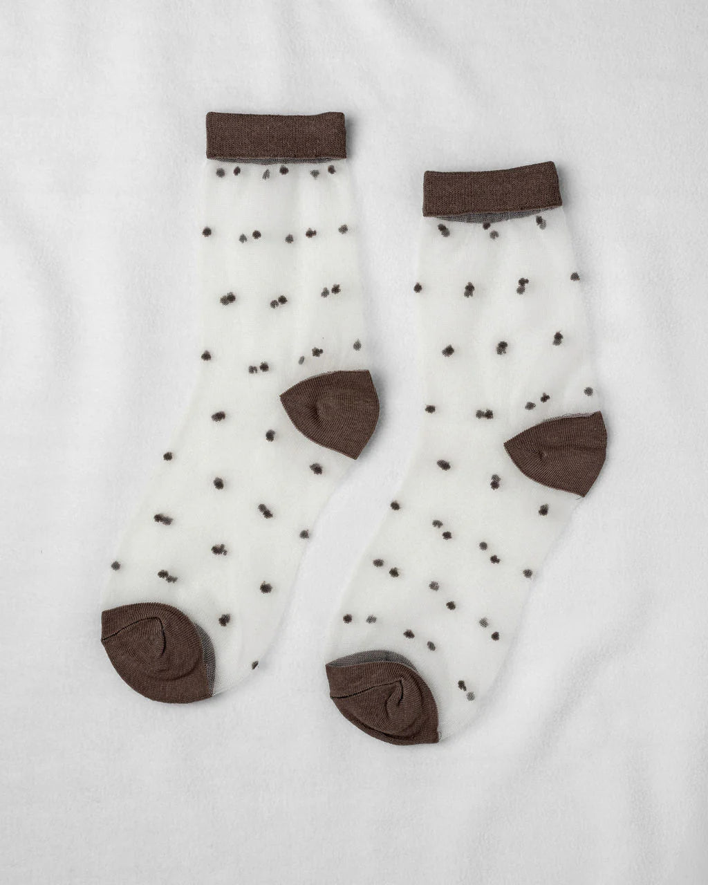 Unified Sheer Dot Socks—sheer anklets with small black polka dots and solid brown heels, toes, and cuffs—are perfect for adding playful flair to women's fashion accessories.