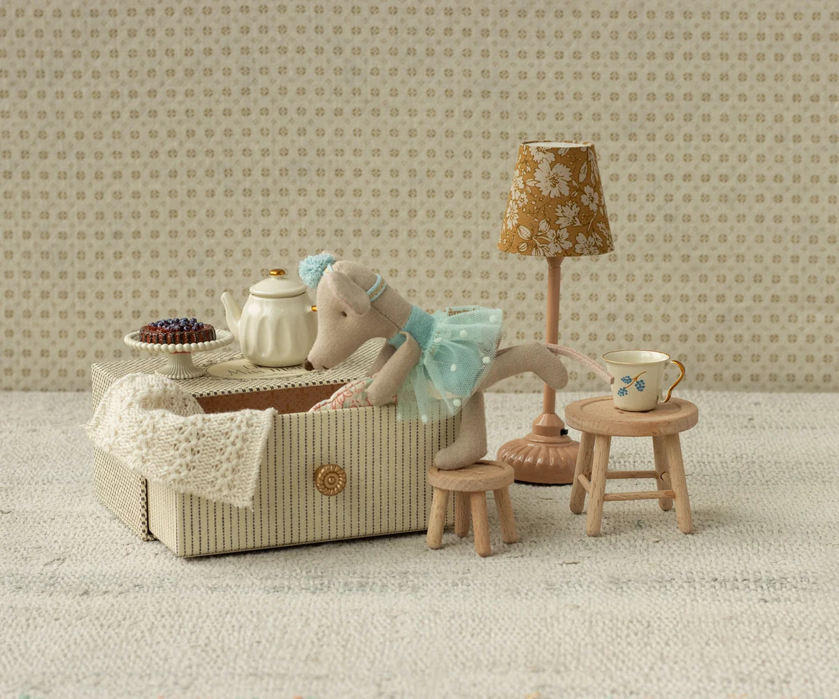 Maileg Dance Mouse Little Sis sits in a daybed, reaching toward a tea table; whimsical nursery decor by Maileg.