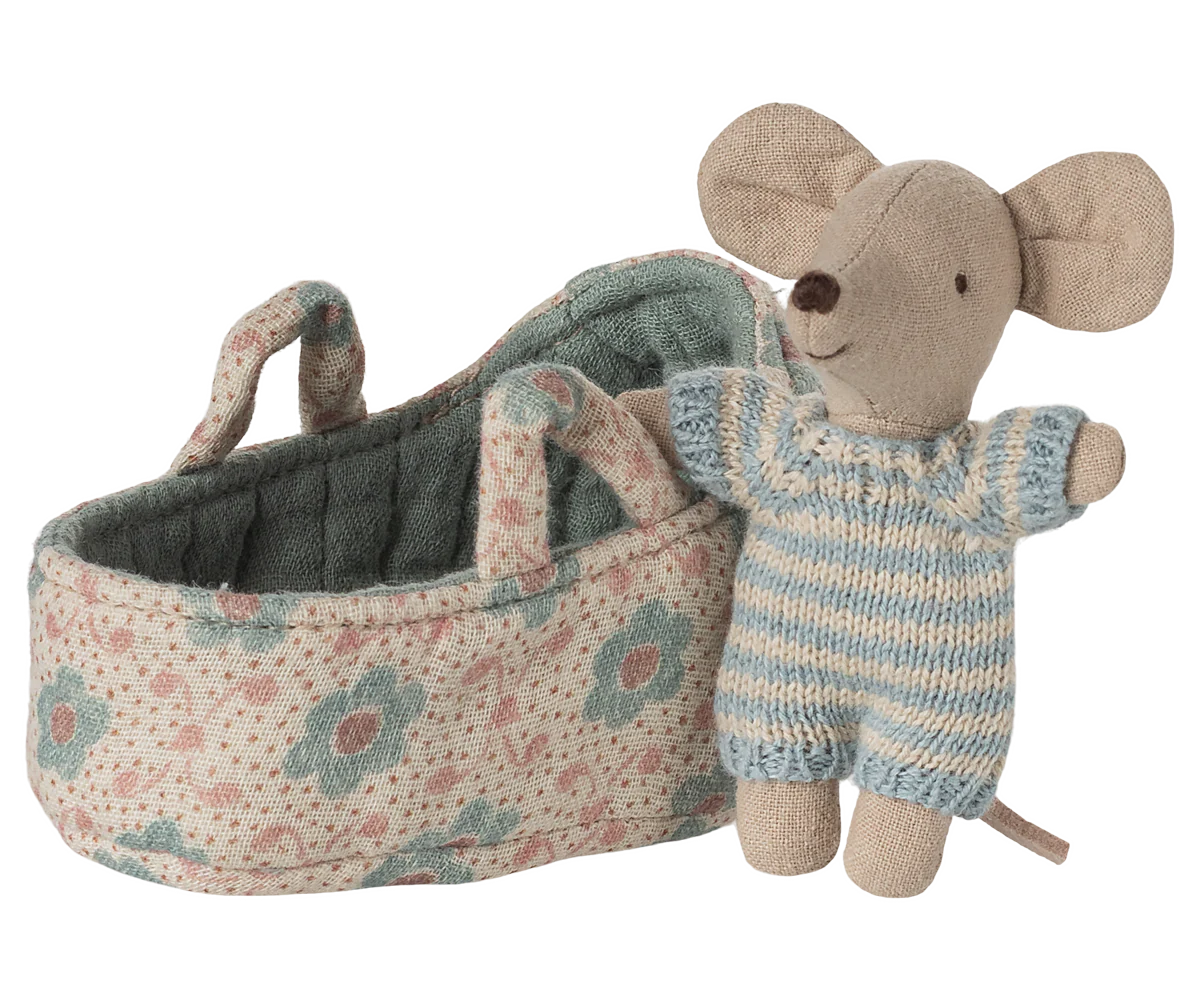 A Maileg Mouse by Maileg, dressed in a blue and white striped knitted outfit, stands beside a floral-patterned fabric basket with handles—an adorable addition to any mouse family collection.