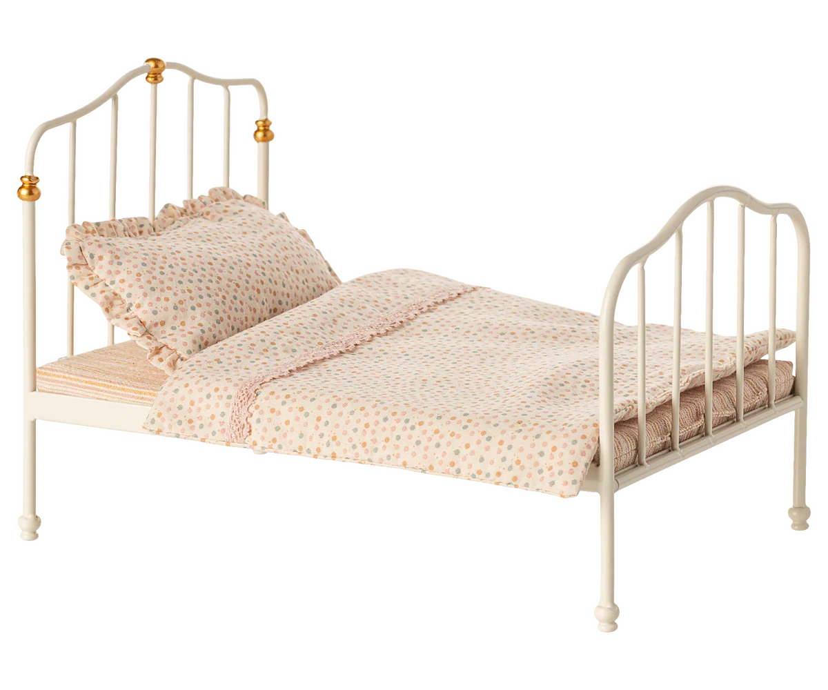 The Maileg Furniture metal bed by Maileg features gold accents, a polka dot pillow, and a pastel ruffled blanket—ideal for Maileg Mouse or dollhouse play. Shown against a plain white background.