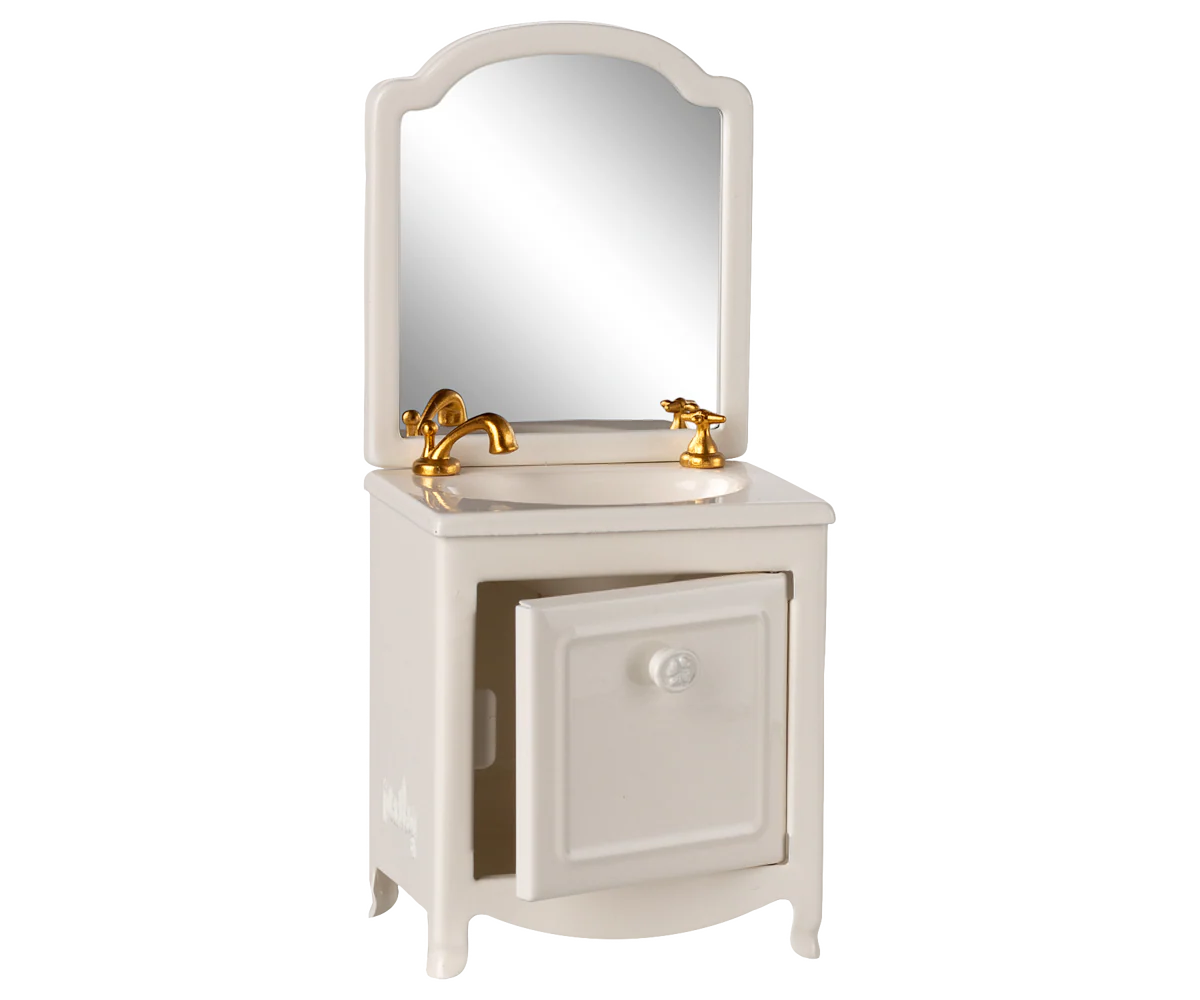 The Maileg Sink Dresser by Maileg is a small white bathroom vanity with a mirror, gold faucet and handles, and an open cabinet door—ideal for a Mouse Hole Farmhouse or Maileg scene, shown against a plain white background.