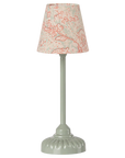 The Maileg Vintage Floor Lamp by Maileg features a pale green ridged base and stem, with a beige lampshade adorned in a pink floral pattern. Its soft glow and vintage design add charm, shown here against a plain white background.