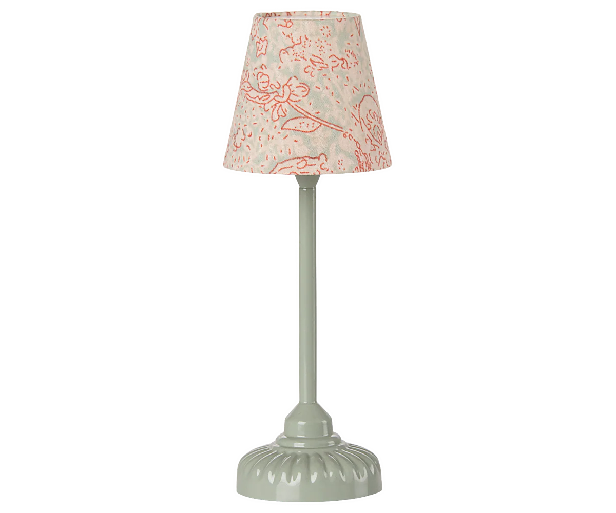 The Maileg Furniture table lamp by Maileg features a pale green round base, straight stem, and a beige lampshade with pink floral accents—perfect for dollhouse decor or a Maileg Mouse setup.
