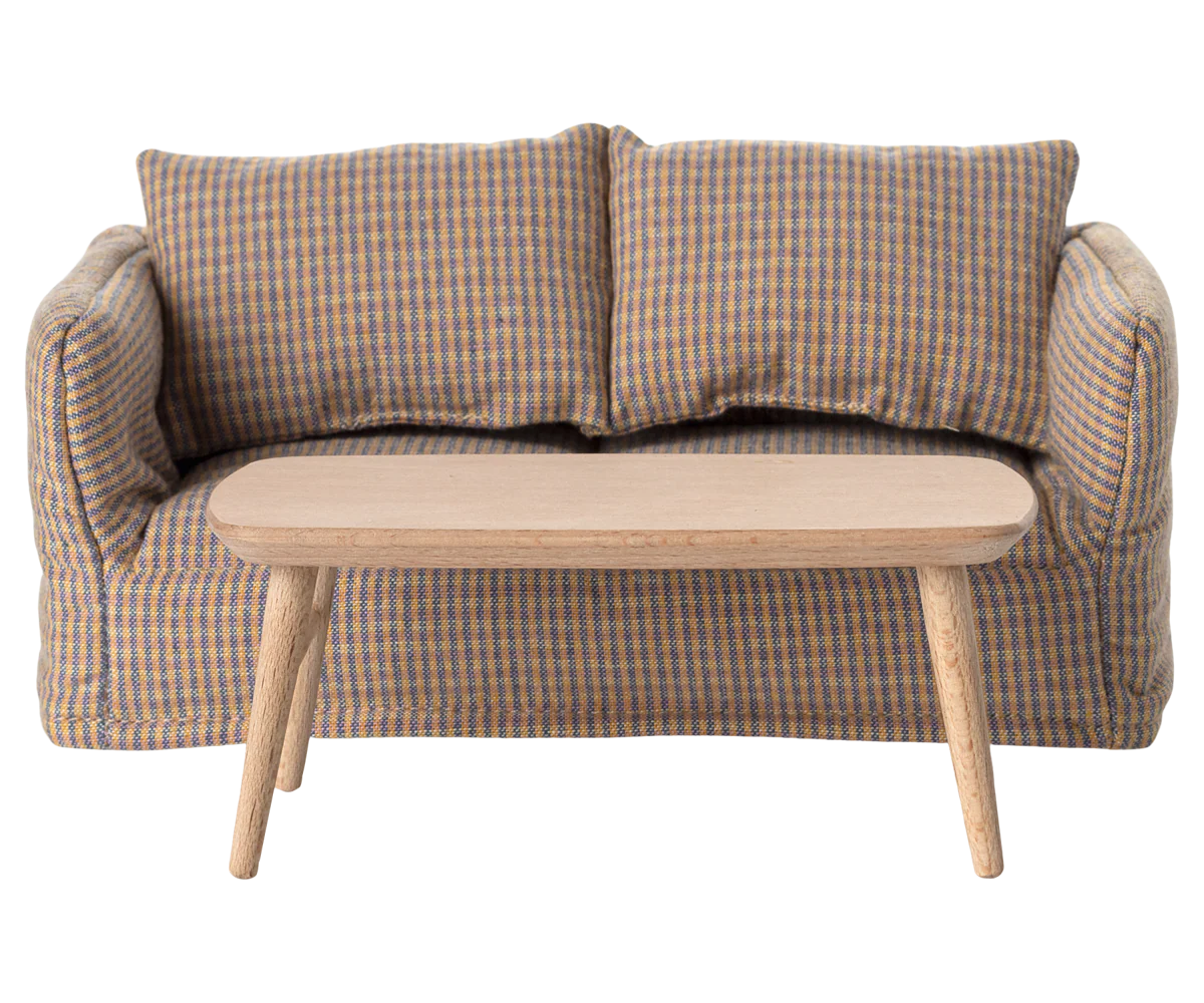 A compact, mouse-sized two-seater sofa with checkered upholstery and two cushions sits behind the Maileg Coffee Table by Maileg, a simple light wood piece with angled legs, all set against a plain white background.