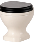The Maileg Water Closet by Maileg is a small, white ceramic toilet with a closed black lid, set against a plain white background—an ideal modern accent for your SuitCasa bathroom.