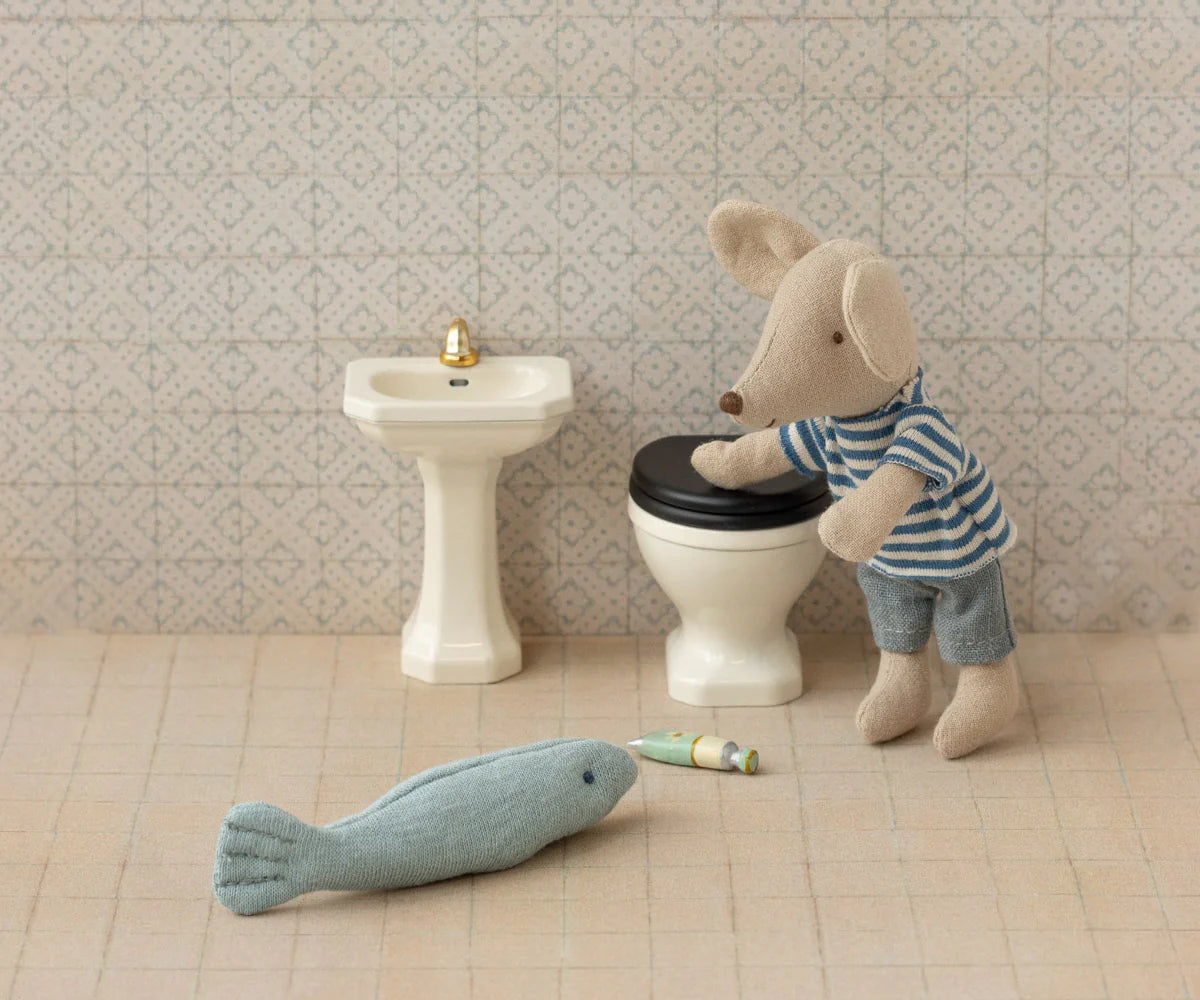 The Maileg Bathroom Sink by Maileg features a small toy mouse in a striped shirt, a miniature toilet and sink, plus tiny accessories—a perfect, charming addition to any dollhouse bathroom.
