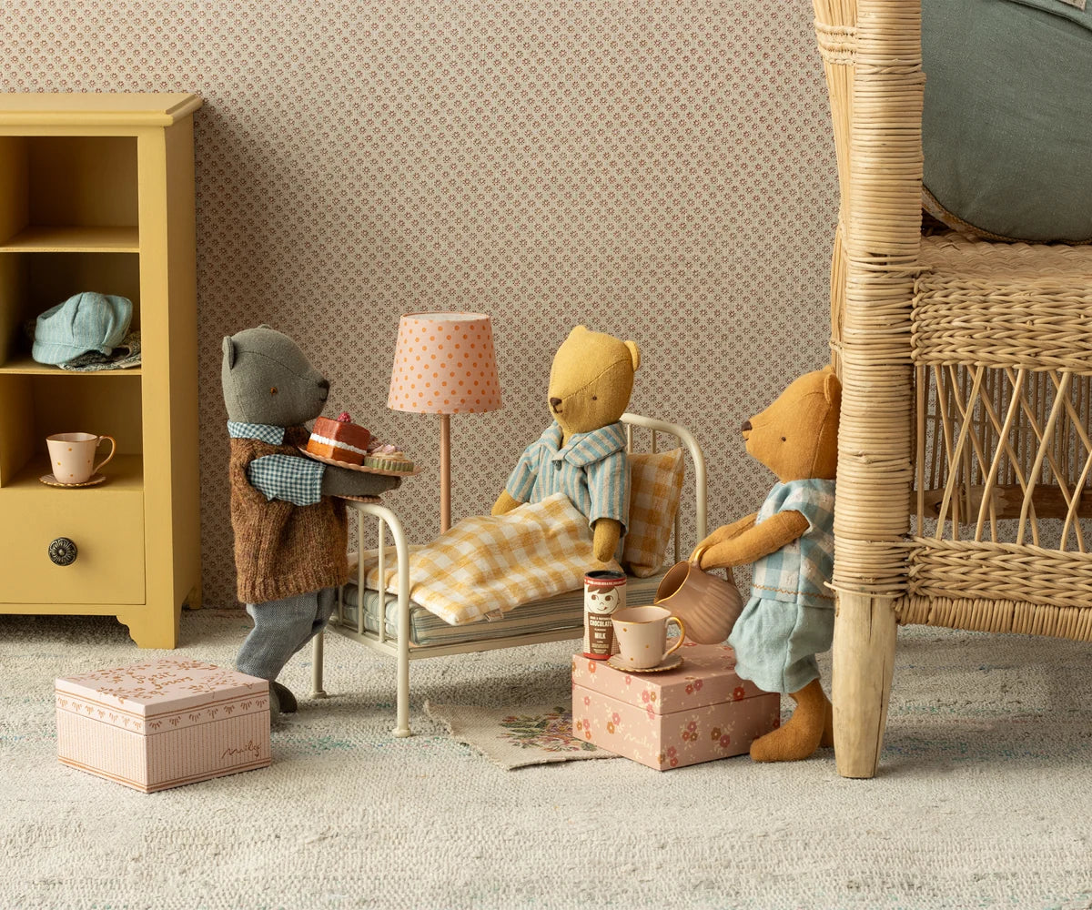 Maileg Mini Hot Chocolate Set in pink boxes with three stuffed bears sharing gifts in a cozy dollhouse bedroom setting.