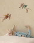 The Maileg Medium Mouse, Pyjamas by Maileg rests on a pillow, looking up at two fairy mice, creating a charming bedtime scene perfect for any child's room.