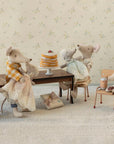 Five Maileg mice, dressed in vintage-style clothes, gather around a table with the Maileg Party cake and a wrapped gift. Two sit on chairs, two stand beside the table, and one stands on a stool holding syrup. Brand: Maileg.