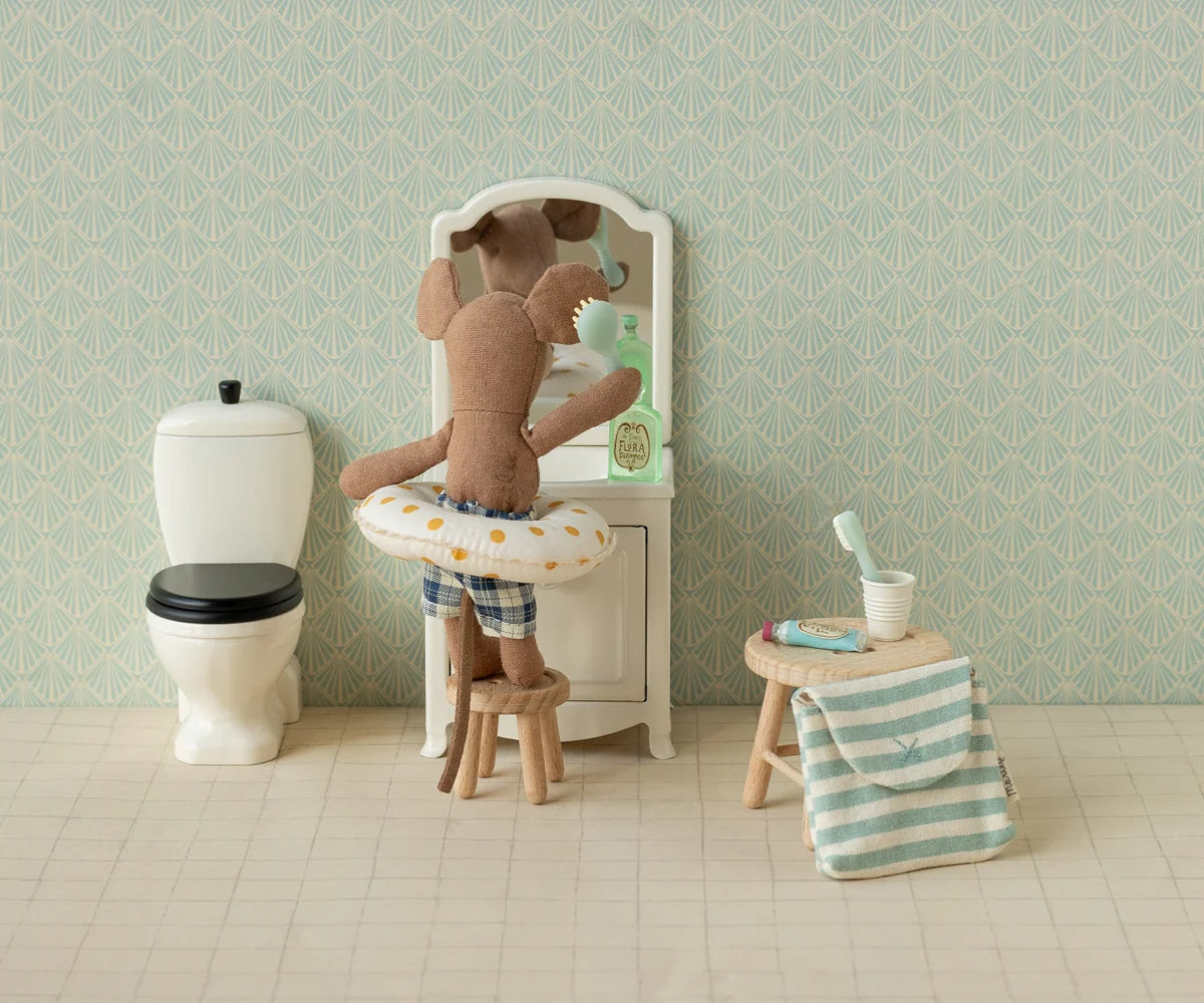 Maileg mouse in a swim ring at a bathroom sink, featuring toothbrush set, towel, and toilet; playful decor by Maileg.
