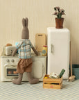Maileg stuffed rabbit in a toy kitchen next to a Maileg toaster with toasted bread, playful and cozy setting.