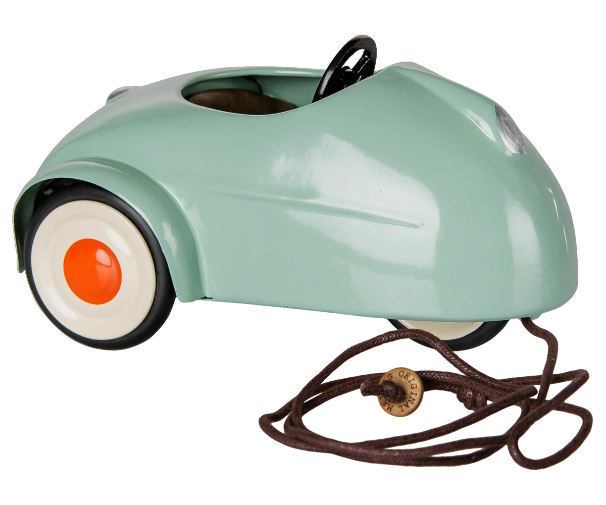 Green vintage-style metal toy car with white wheels and brown pull string by Maileg.