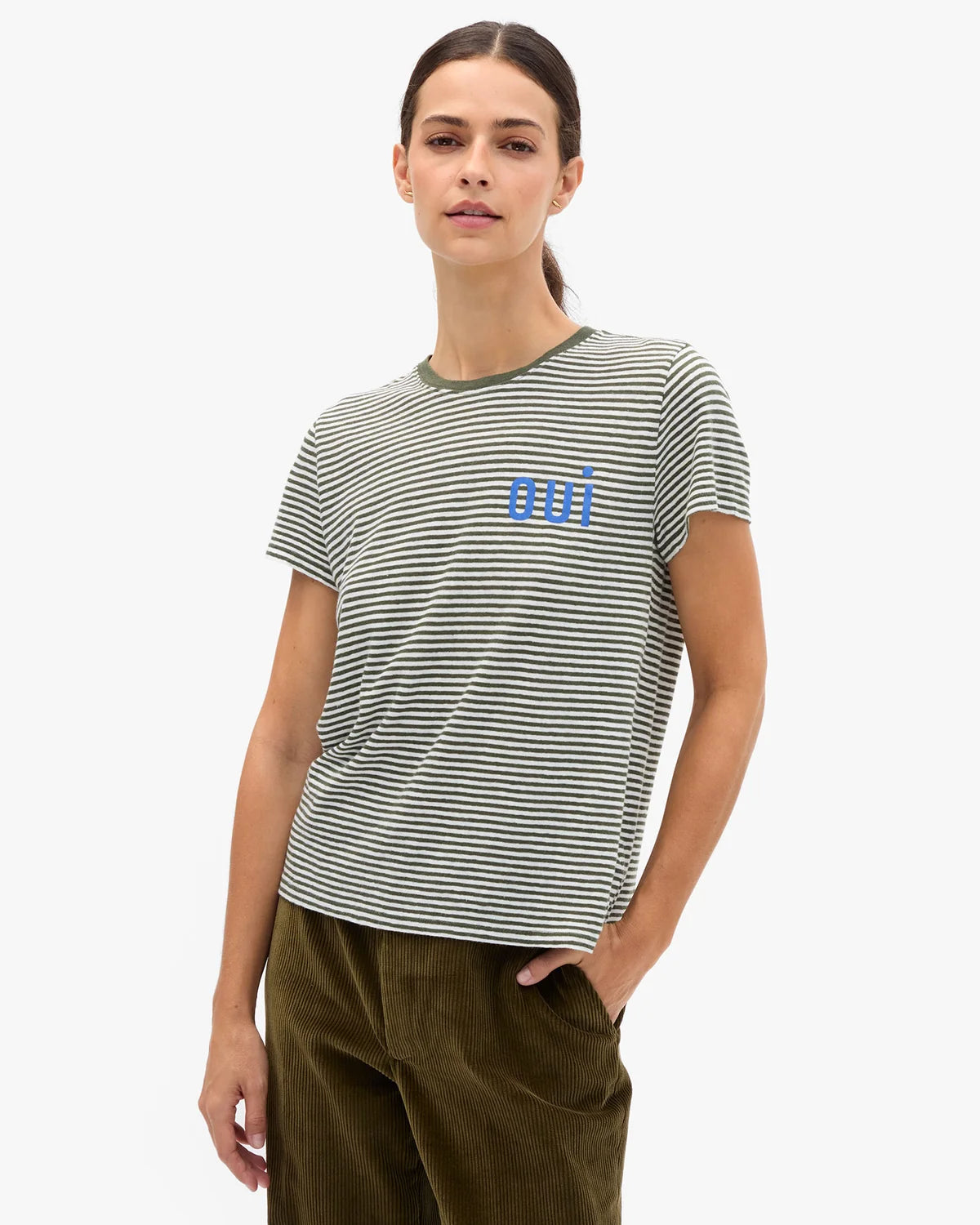 Clare Vivier Classic Tee OUI in Army Cream paired with green pants, casual style, hand-in-pocket pose.