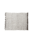 The Bloomingville New Zealand Wool Shag Throw, a rectangular plush grey rug crafted from a wool blend, lies flat against a white background. Its textured fabric and fringe on the shorter sides add an elegant touch, making it ideal for luxury decor enthusiasts.