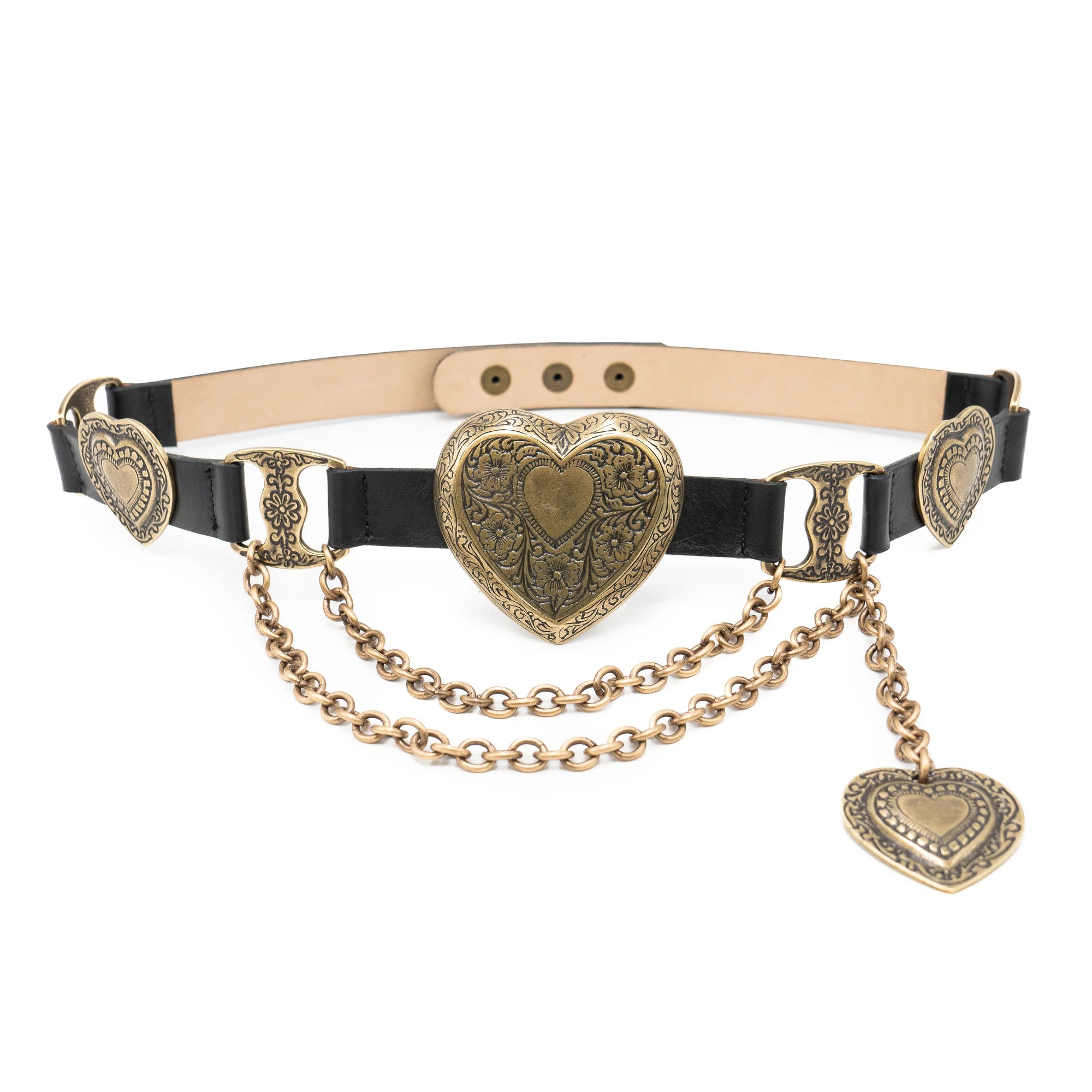 The Brass XL Heart Belt by Streets Ahead Inc, handcrafted in Los Angeles with Italian brass hardware, features ornate gold heart-shaped buckles, decorative engravings, draped gold chains, and a dangling heart charm for an elegant statement.