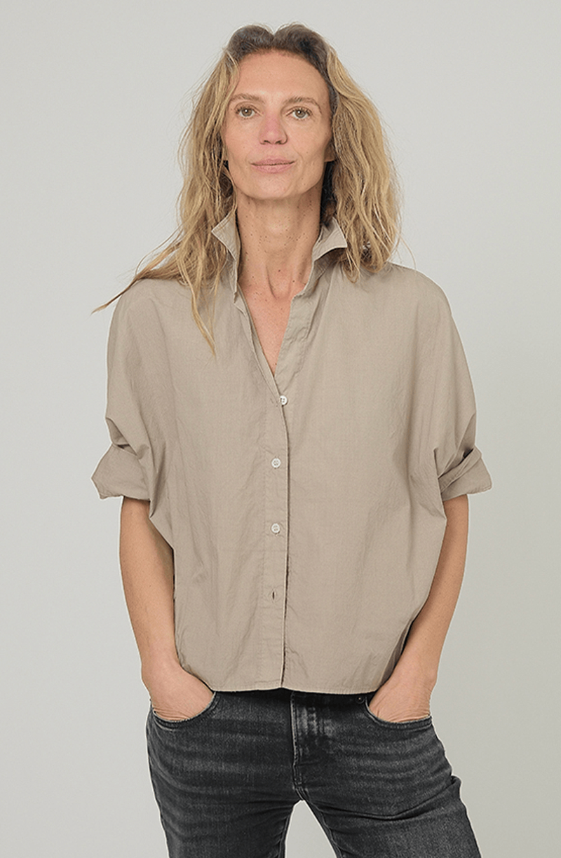 Monday12 Daria Shirt in Army Beige styled with black jeans, modeled with hands in pockets facing camera.