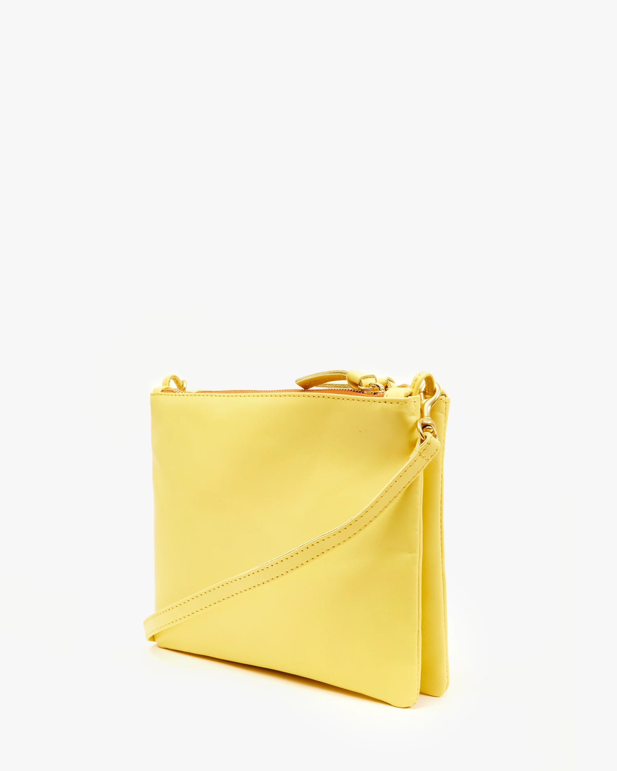 The "Double Sac Bretelle" by Clare Vivier is a sleek, rectangular yellow crossbody bag crafted from Italian leather and boasts a minimalist design. It features a zip closure at the top and comes with a slim, detachable shoulder strap attached by gold hardware. The bag is photographed standing upright against a plain white background.