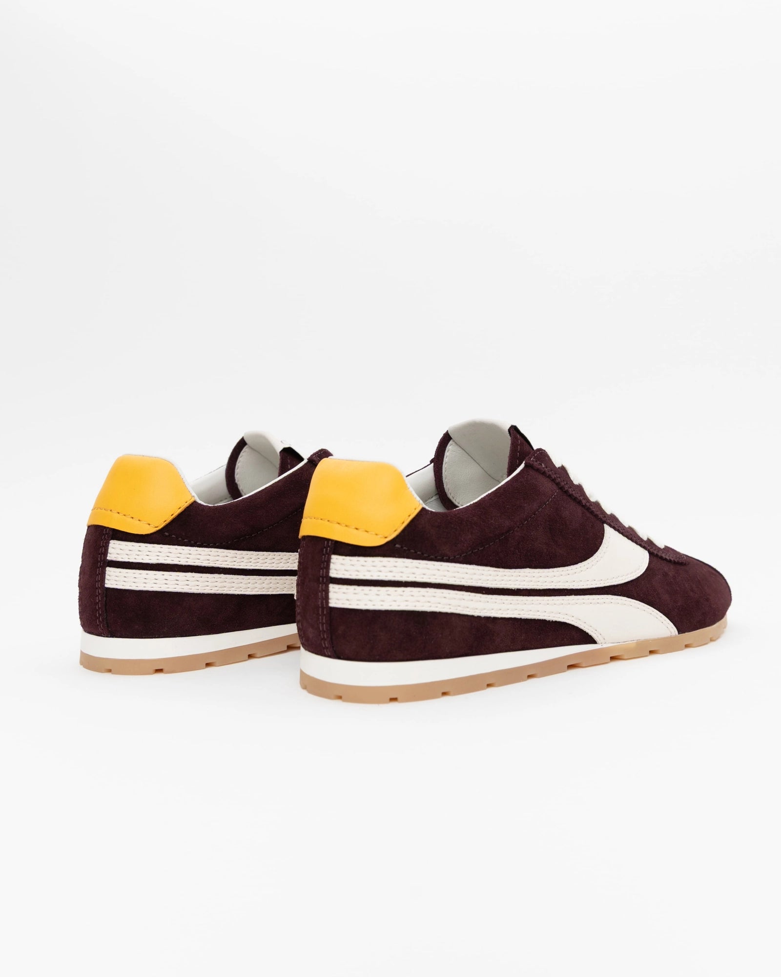 The ONCEPT Essex Sneaker, crafted from ultra-lightweight maroon Italian suede with white accents and yellow heel tabs, is shown on a white background from the back and side views.
