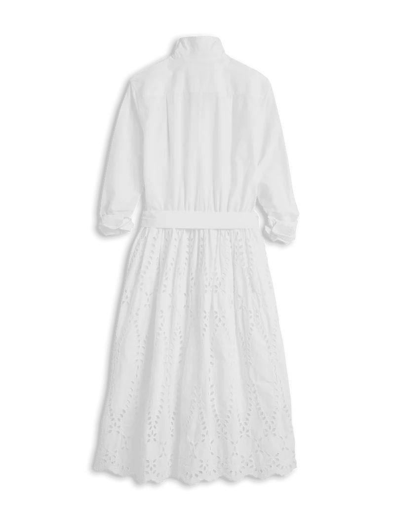 The Gracie Midi Eyelet Dress by Frank & Eileen features long sleeves, a collared neckline, a belted waist, intricate patterns, and a scalloped hem. Displayed on a black background, this elegant dress is machine washable for easy care.