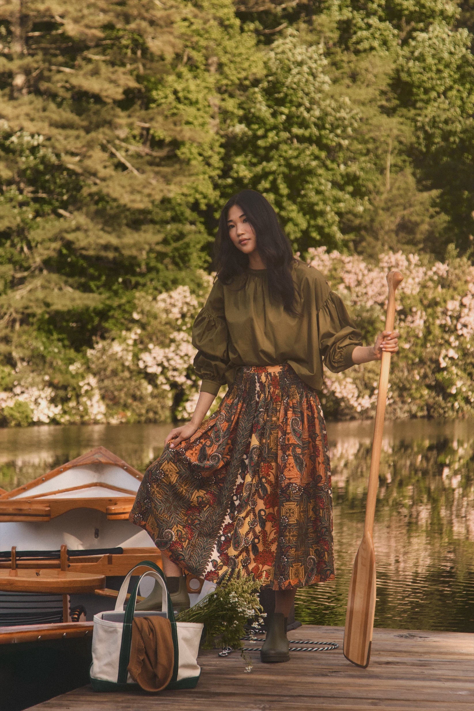 Hunter Bell NYC Eli Top worn outdoors on a wooden dock, creating a relaxed lakeside vibe with natural surroundings.