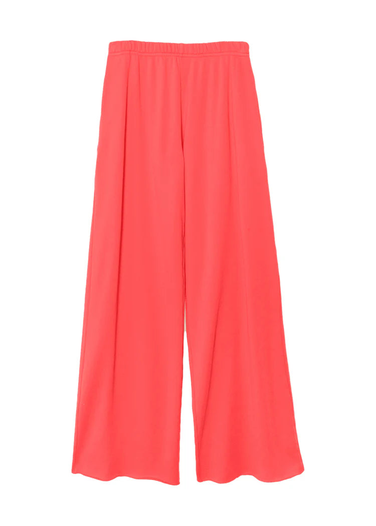 The Emmette Sweatpant by Xirena is a bright coral pink, wide-leg fleece pant with an elastic waistband and relaxed, loose fit. Made in Los Angeles, these sweatpants have no visible pockets or embellishments.