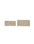 Two Creative Co-op hand-woven rectangular rattan boxes with loop closures, the left smaller than the right, are set against a white background. Their bleached finish adds elegance to any space.