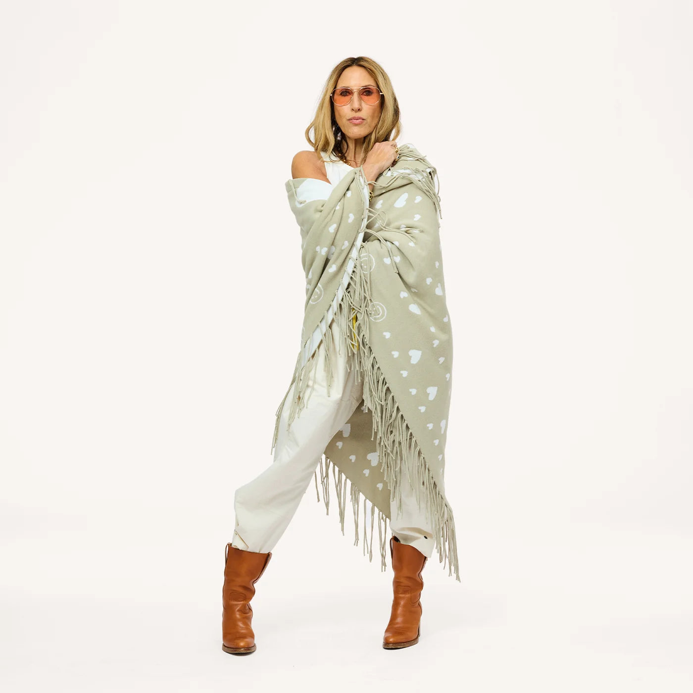 Imperfect Heart cotton-knit poncho with drippy heart design by Kerri Rosenthal, styled with boots and sunglasses.