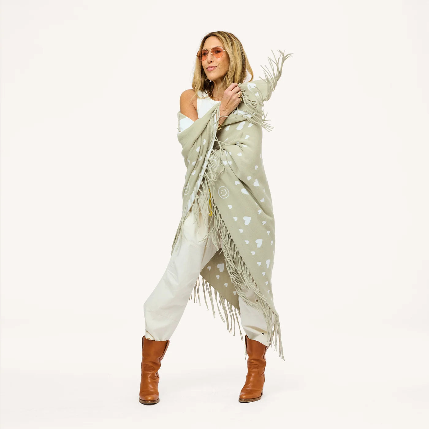 Kerri Rosenthal Imperfect Heart Poncho in cotton knit with heart pattern, styled with sunglasses and brown boots.