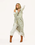 Kerri Rosenthal Imperfect Heart Poncho in cotton knit with heart pattern, styled with sunglasses and brown boots.