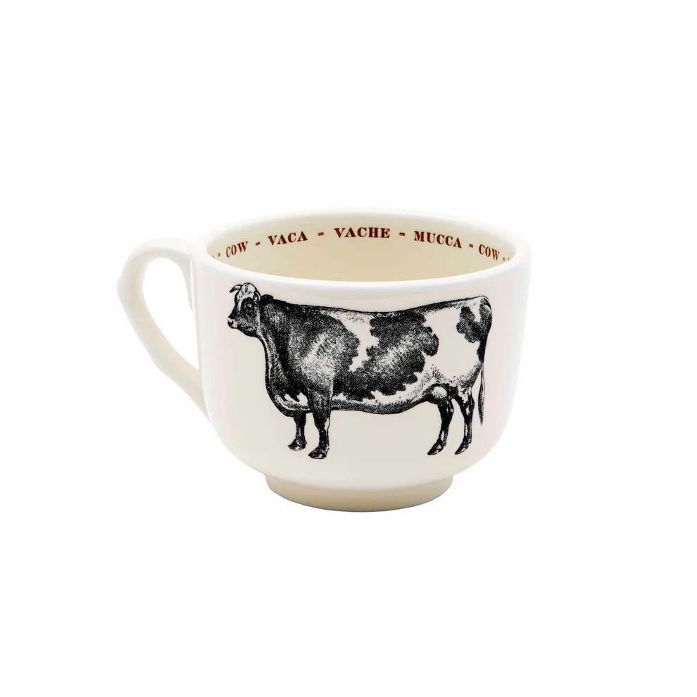 The Sir/Madam Grand Cup is a white ceramic animal cup with a black cow illustration on the side and "cow" written in several languages around the inner rim.