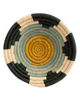 A circular, flat Woven Bowl 6" by Kazi Goods featuring a concentric spiral pattern in natural, black, and pale green colors on a white background, perfect for any bungalow in Scottsdale, Arizona.