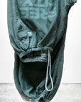 Flap/Snap LG MATTE/SATIN AirJump Pant by Free City (sparrow, LLC) features green fabric with "FREE CITY" and an orange graphic, sunfade washed in Los Angeles. Displayed upside down; "freecitysupershop" shown at the bottom.