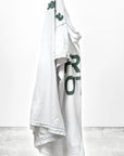 A unisex, white hand-screen printed t-shirt from Free City (sparrow, LLC), featuring green "thedoingofitisthebeingofit" text, is displayed on a plain background. "freecitysupershop" appears in bold black letters at the bottom.