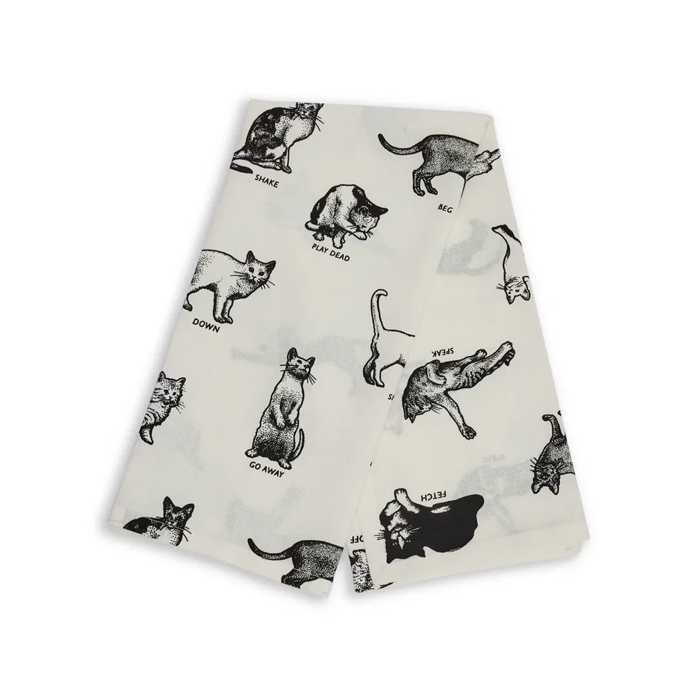 Black cat illustrated tea towel with playful text, Fishes Eddy Cat Tricks, cotton, 20x28 inches, kitchen accessory.