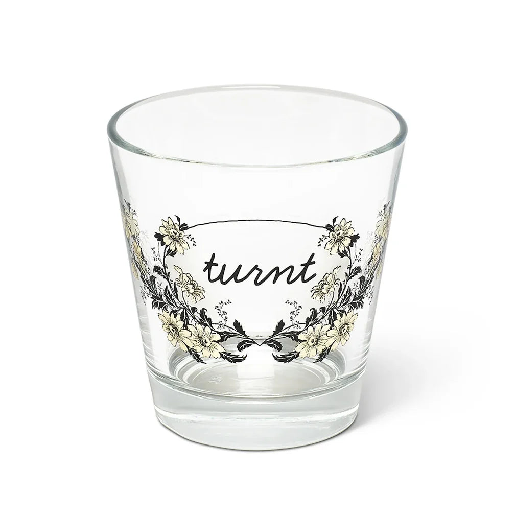 Clear glass tumbler with floral pattern and turnt cursive by Fishes Eddy, made in Italy.