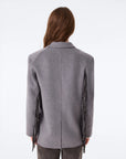 KUJTEN G3 gray flannel blazer with fringe sleeves shown from back, model with straight brown hair.