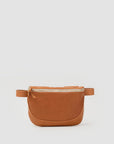 The Clare Vivier Fanny Pack Fall 25 is a chic everyday staple, featuring tan natural grain leather, rounded edges, and a zip closure, showcased against a plain light gray background.