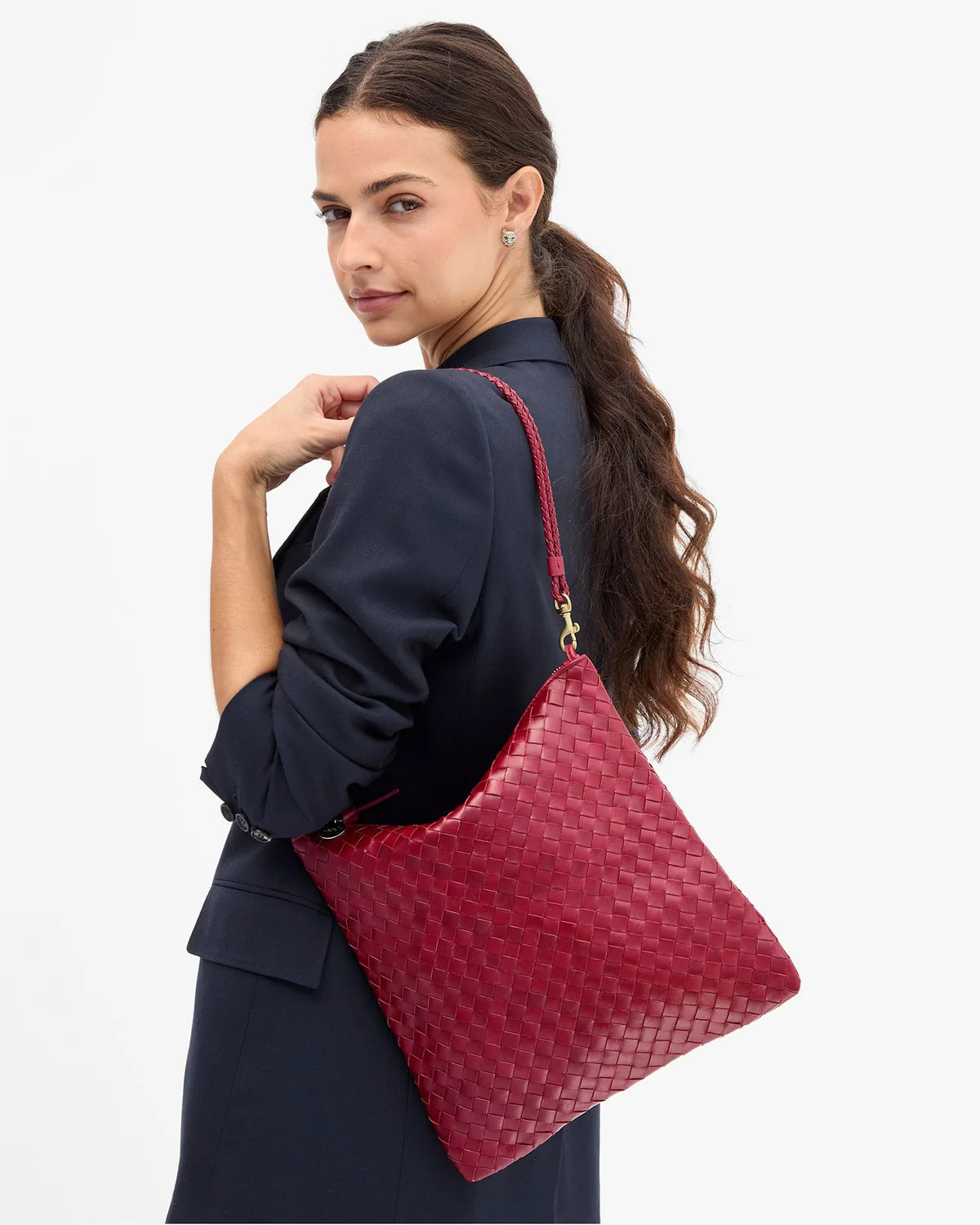 Clare Vivier Foldover Clutch Medium with strap, carried by woman in navy blazer, chic casual style.