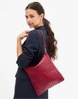 Clare Vivier Foldover Clutch Medium with strap, carried by woman in navy blazer, chic casual style.