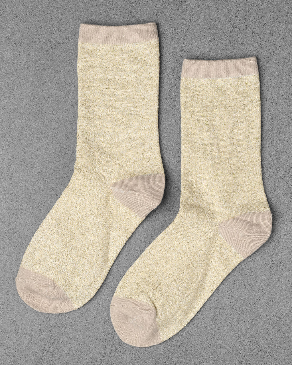 Unified Glitter Socks in light yellow feature beige toes, heels, and cuffs, shown on a gray background.