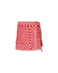 The Bay Skirt by Hunter Bell NYC is a fitted mini skirt with red and white yarn-dyed stripes in vertical and horizontal patterns. It features decorative trim with semi-circular designs and a tied ribbon on the side for an elegant wrap-around look.