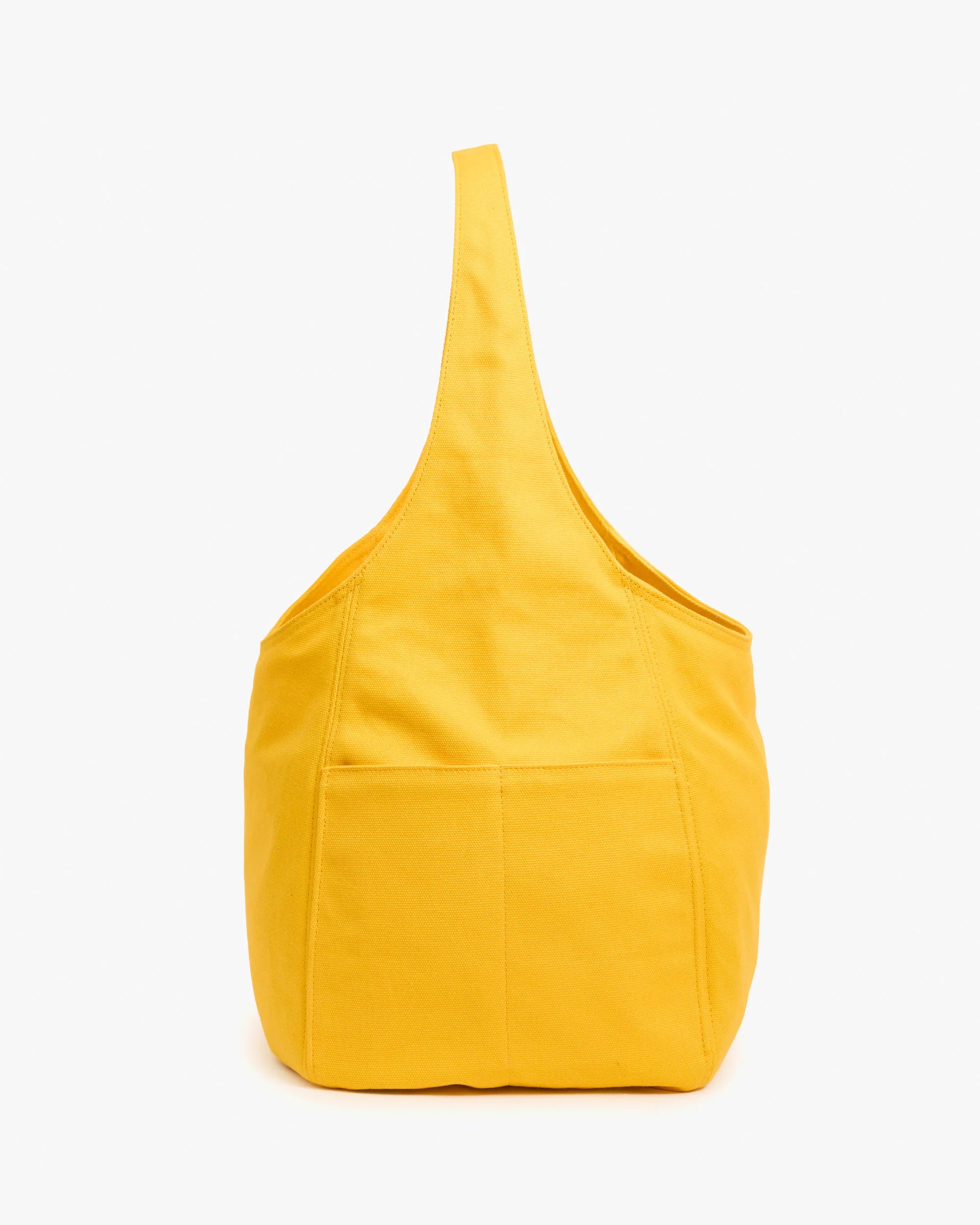 The Clare Vivier Grand Bando Canvas is a bright yellow cotton tote with a wide strap, visible outer stitching, and front pocket, pictured upright against a white background. This vegan bag blends style and practicality.