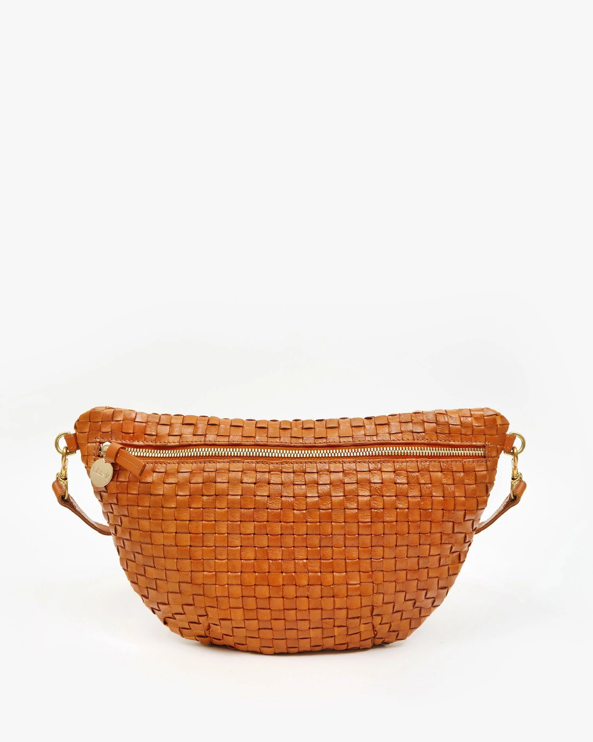The Grande Fanny S25 by Clare Vivier is a brown handwoven leather crossbody bag with a gold zipper and adjustable strap, displayed against a plain white background.