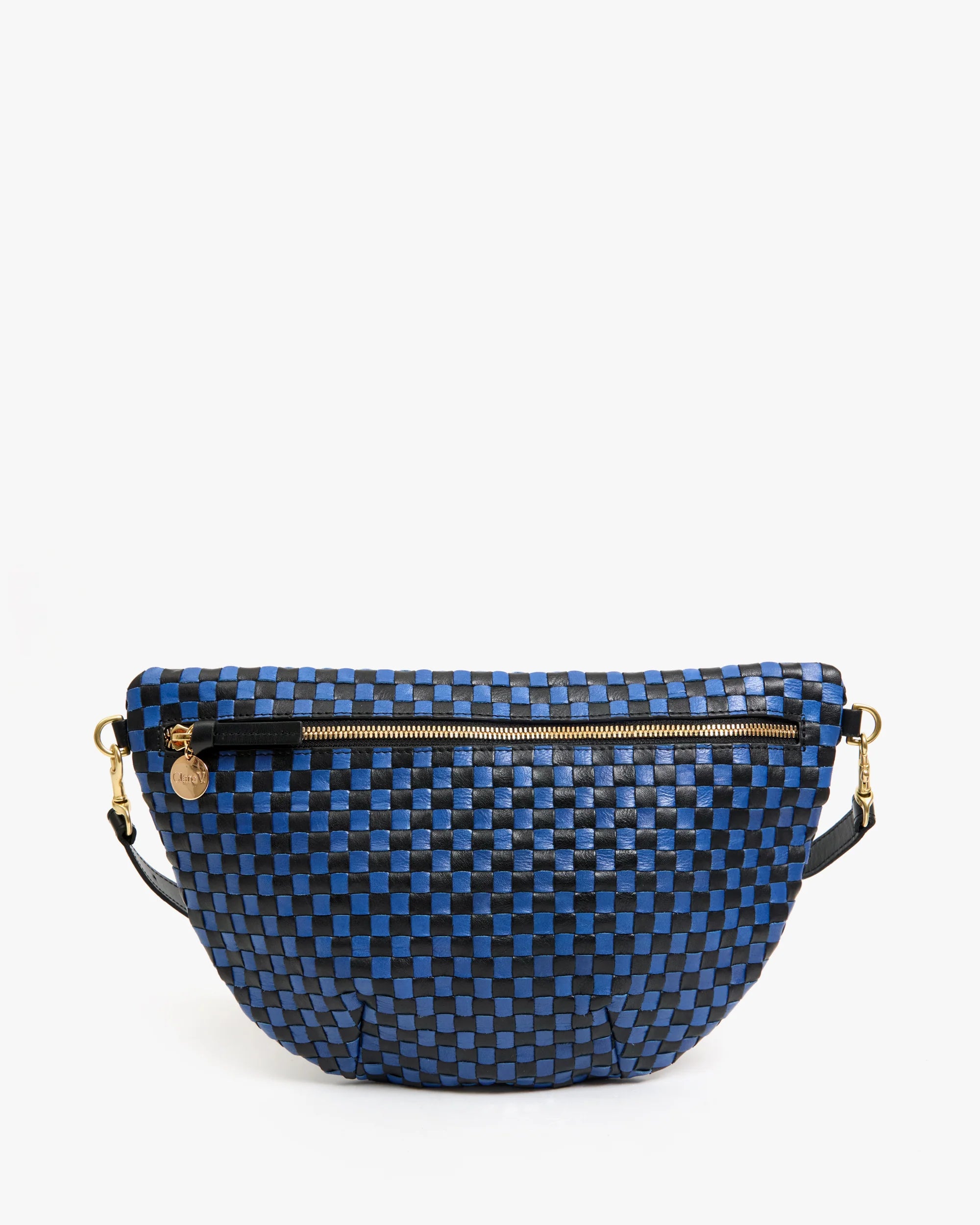 The Clare Vivier Grande Fanny S25 is a blue and black checkered handwoven leather crossbody bag with a gold zipper, round gold charm, and black adjustable straps, shown against a plain white background.
