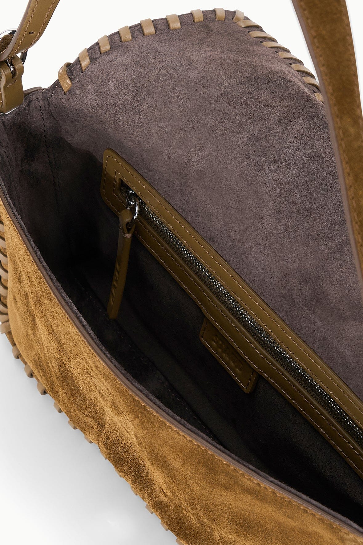 Open brown suede Staud Harlow shoulder bag with stitched edge, zip pocket, and soft suede lining.